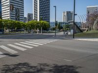 an empty street has several buildings in the background and there is a pedestrian crossing in the middle of the road