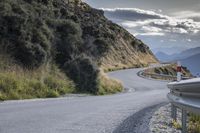 a curved road leads toward an overlook with hills in the distance and a red sign that says'climb on the top '