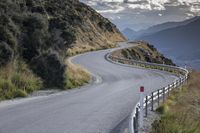 a curved road leads toward an overlook with hills in the distance and a red sign that says'climb on the top '