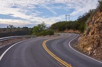 the curved roads are surrounded by rocks and grasss against a background of sky and trees