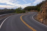 the curved roads are surrounded by rocks and grasss against a background of sky and trees