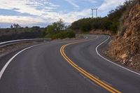 the curved roads are surrounded by rocks and grasss against a background of sky and trees