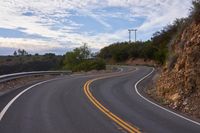 the curved roads are surrounded by rocks and grasss against a background of sky and trees