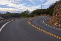 the curved roads are surrounded by rocks and grasss against a background of sky and trees