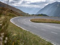 a motorcyclist rides down a curved roadway in the countryside of a valley