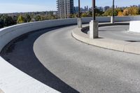 a curved roadway next to the ocean on a sunny day in canada and a building