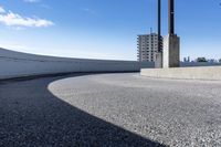 a curved roadway next to the ocean on a sunny day in canada and a building