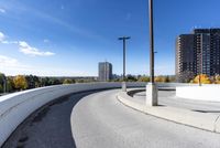 a curved roadway next to the ocean on a sunny day in canada and a building