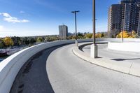 a curved roadway next to the ocean on a sunny day in canada and a building