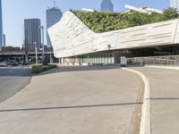 a curved walkway on the side of an empty street in a city area with tall buildings