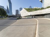 a curved walkway on the side of an empty street in a city area with tall buildings