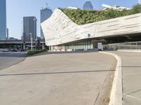 a curved walkway on the side of an empty street in a city area with tall buildings