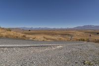 a road curves around a curve with mountains in the distance and no parking sign or sign on it