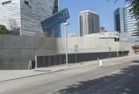 a big building sitting next to a street with buildings in the background at one end