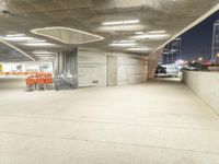 an empty parking lot at night time with orange chairs set out for people to eat