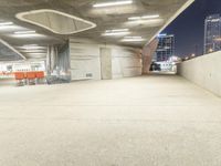 an empty parking lot at night time with orange chairs set out for people to eat