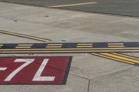 an airport runway with red and white markings of 23r - 3l numbers on the pavement