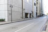 an empty street in front of buildings and tall building with multiple lamps and a bicycle rack