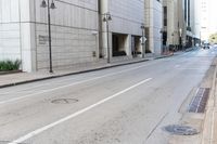 an empty street in front of buildings and tall building with multiple lamps and a bicycle rack