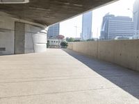 a person on a bicycle traveling under a bridge by itself in the cityscape