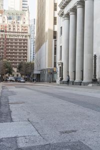 a guy on his skateboard goes down the street in city area with several tall buildings