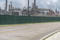 a large industrial plant in front of the highway and a bike path behind it is on concrete pavement