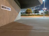 a parking garage and a sign for general public transportation is pictured in the dark side of a road