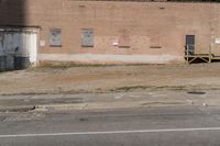 a street sign with signs on the building side of it and dirt next to the road