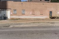 a street sign with signs on the building side of it and dirt next to the road