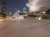 the building that houses the modern arts is lit up by green lights, at night