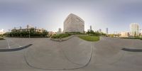 a 360 - view of an upside down skate boarder in the city park under a blue sky