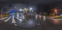 an intersection with street lights, buildings and palm trees at night, in a dark city