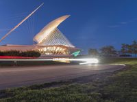 the art museum is lit up with lights on the sky and on the sidewalk in front of the building