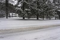 a country cabin surrounded by snow covered pine trees near a road in a park with snow covered ground