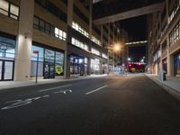 an empty city street during a dark night with the lights on and no vehicles going