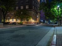 a city street at night with parking meters on either side and the road in the center