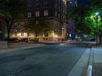 a city street at night with parking meters on either side and the road in the center