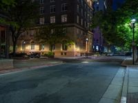 a city street at night with parking meters on either side and the road in the center