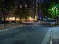 a city street at night with parking meters on either side and the road in the center