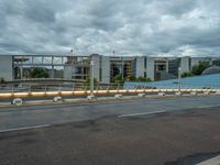 the sky is cloudy and dark over an empty street with two buildings in the back