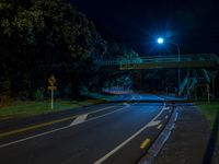 a dark street with an overpass lit by some lights with lots of light on top