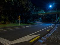 a dark street with an overpass lit by some lights with lots of light on top