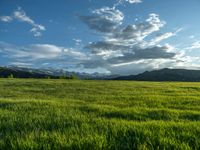 a lone country road is in the countryside area with mountains on both sides and barbed fence between the two sides