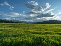 a lone country road is in the countryside area with mountains on both sides and barbed fence between the two sides