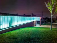 a building with grass and a street light in it at night time under some lights