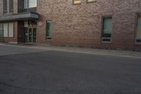 a building with two windows on the side of it and an old car parked by the side