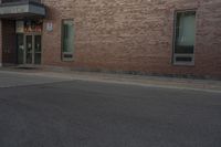 a building with two windows on the side of it and an old car parked by the side