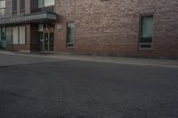 a building with two windows on the side of it and an old car parked by the side