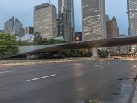 city street and road with highway with bus lanes in the evening time, and skyscrapers in the background