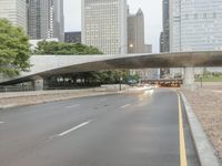 city street and road with highway with bus lanes in the evening time, and skyscrapers in the background